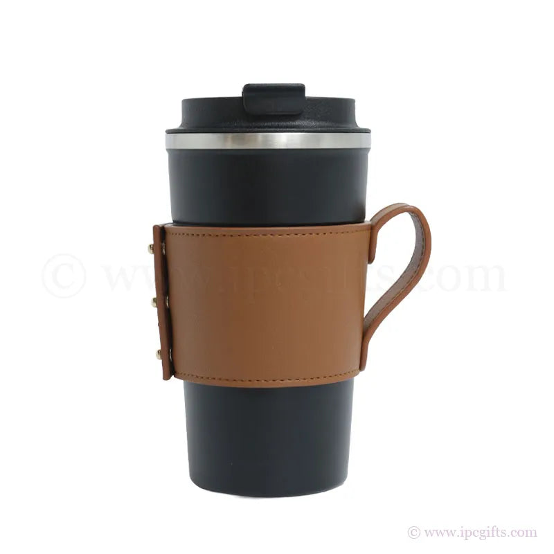 Black travel mug with a thick brown leather sleeve on a white background