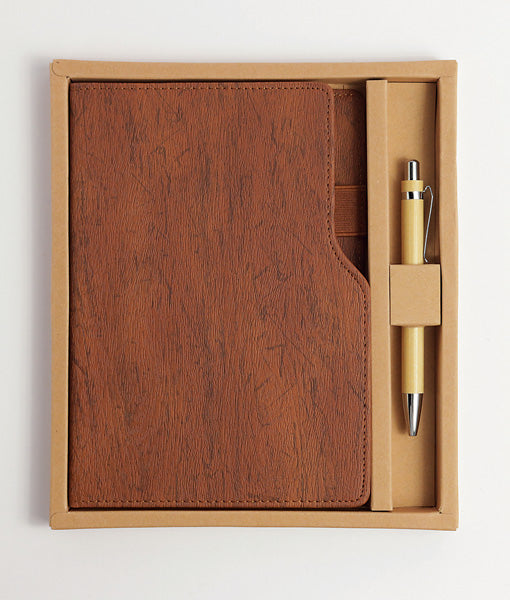Brown leather notebook and pen set in a box on a white background