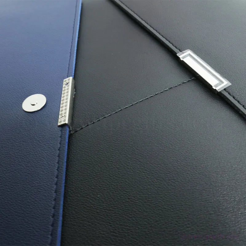 Close-up of a blue and black leather seminar folder with metal accents
